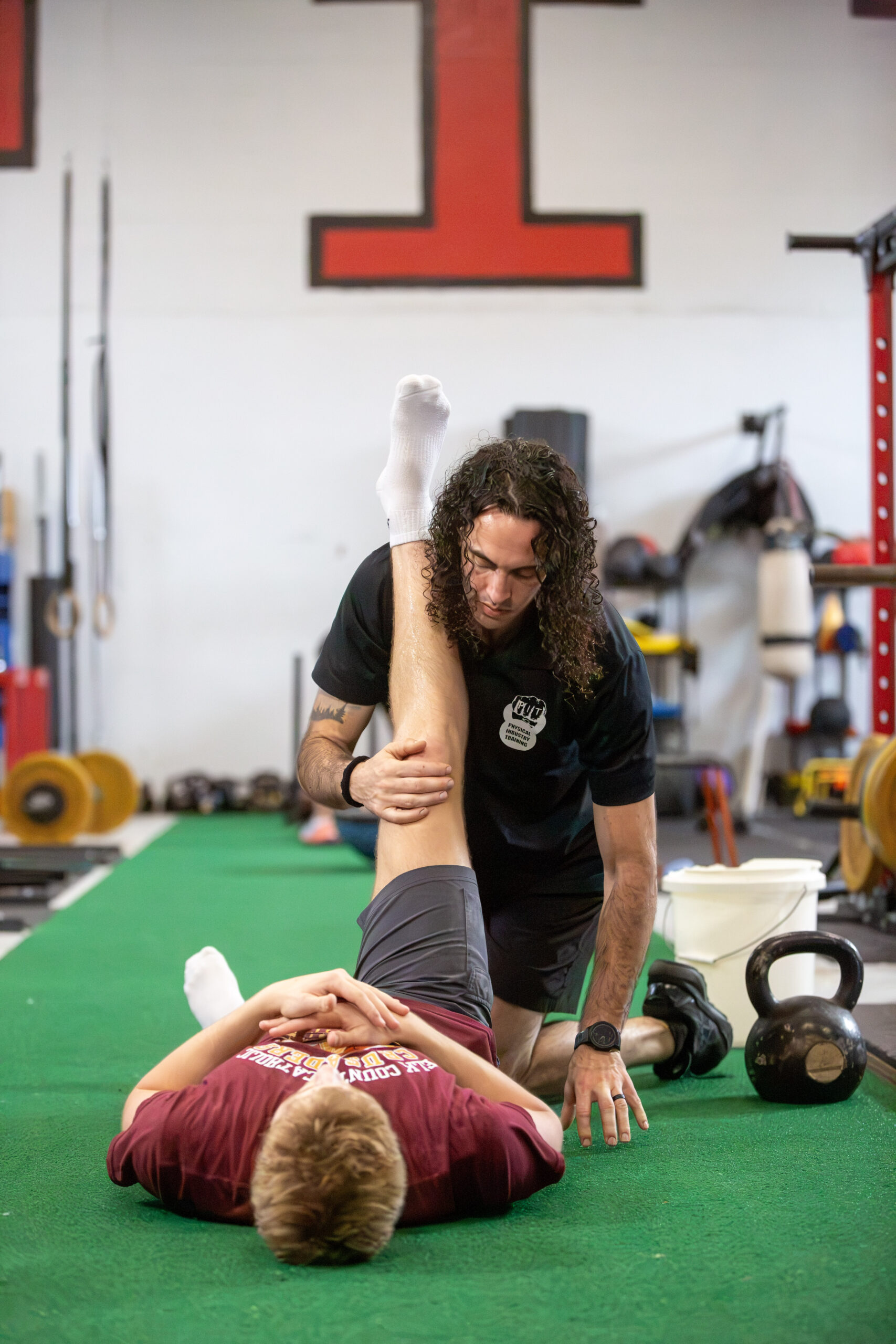 Coach Nick Lavella guiding an athlete through mobility work at Physical Industry Training
